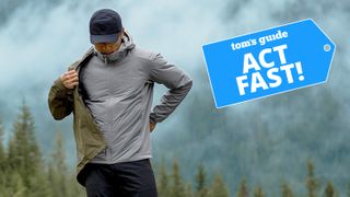 A gentlemen in the mountains takes off one of his Arc'teryx outer layers.