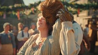 Alexander Skarsgard as a man made of wicker, holds Olivia Coleman in a lusty embrace in front of the townspeople in Wicker.