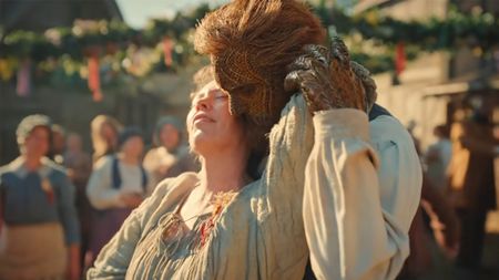 Alexander Skarsgard as a man made of wicker, holds Olivia Coleman in a lusty embrace in front of the townspeople in Wicker.