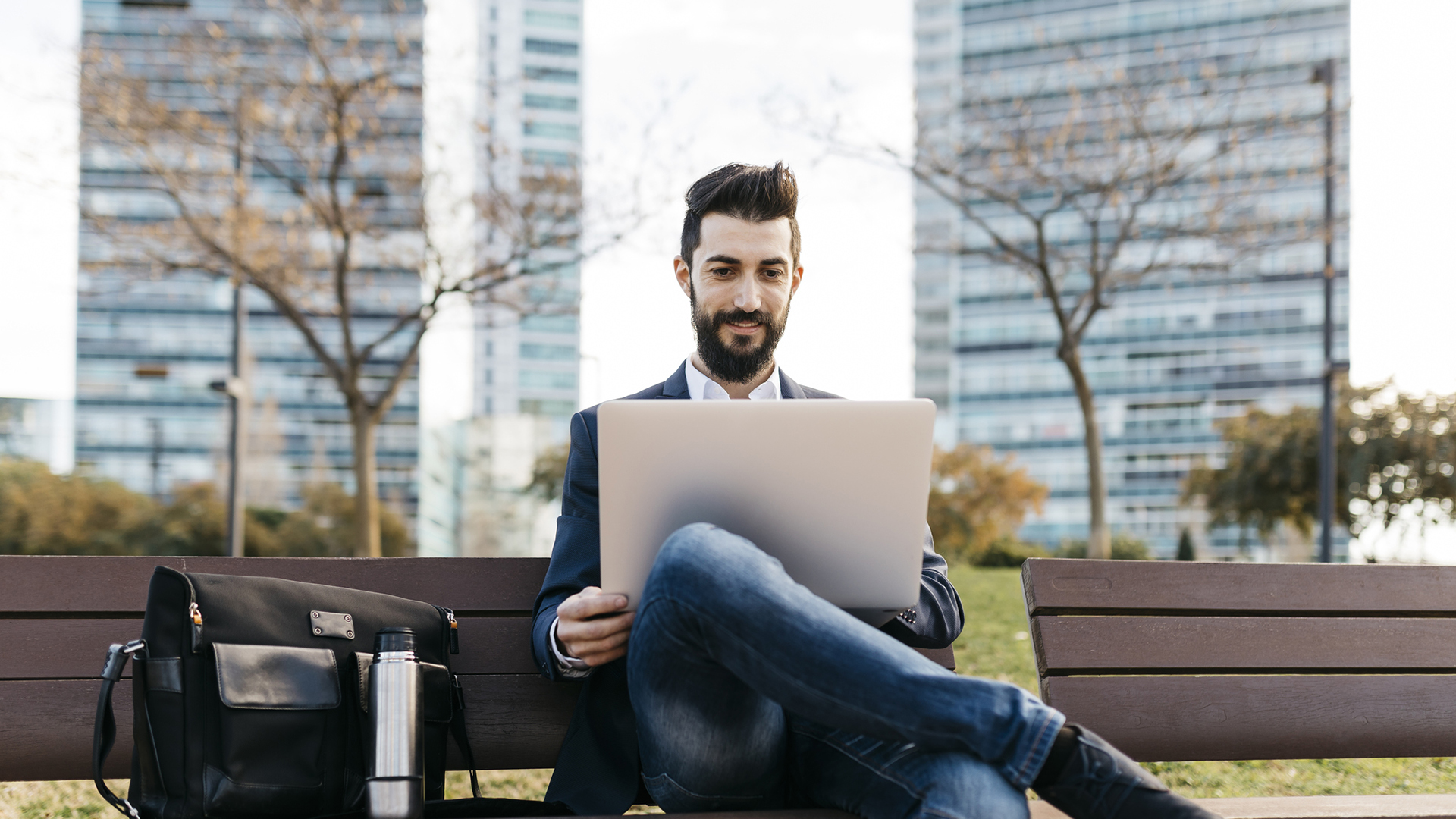 man using laptop in a park