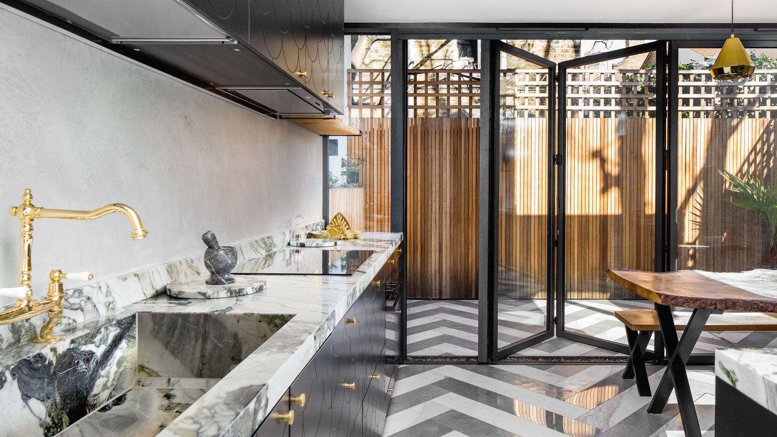 black aluminium bifold doors with level threshold in black kitchen with marble worktops
