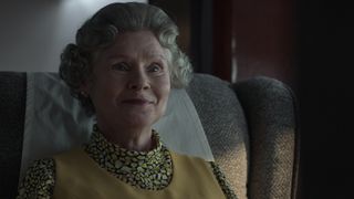 Queen Elizabeth II smiles as she sits on a chair in The Crown season 5, which preceded The Crown season 6