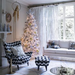 white living room with christmas tree and sofa set