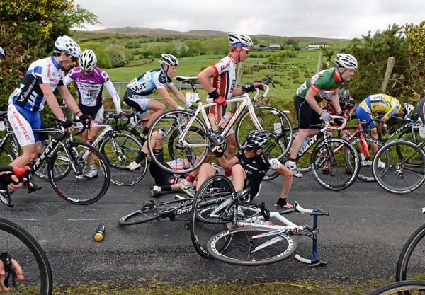 Richard Tanguy (UK Youth Pro Cycling) lies injured as Christopher Jennings (Rapha Condor Sharp) attempts to pick himself up following a crash on the approach to Tourmakeady
