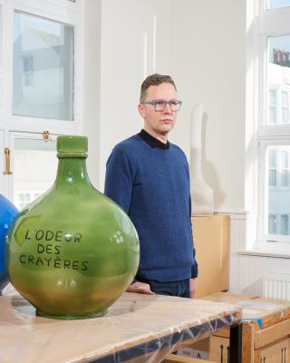 David Shrigley in his Brighton studio with ceramic vessel from his collaboration with Ruinart