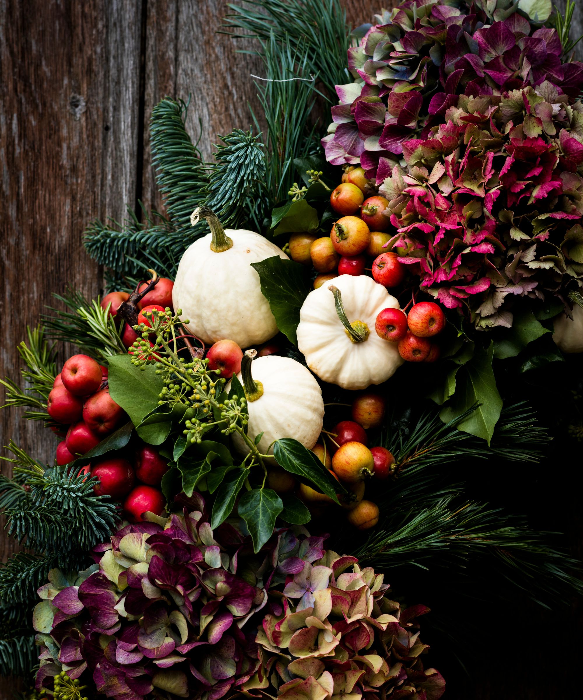 Halloween arrangement with white pumpkins, hydrangeas, crab apples and fir