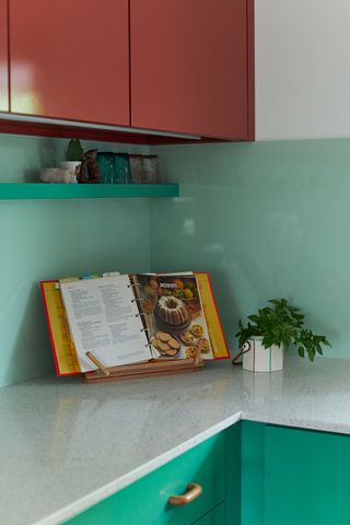 kitchen with red wall cabinets white worktop green base units