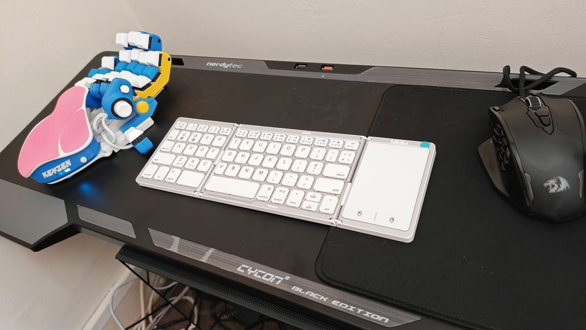 The SEENDA Foldable Bluetooth Keyboard unfolded next to an Azeron Keyzen