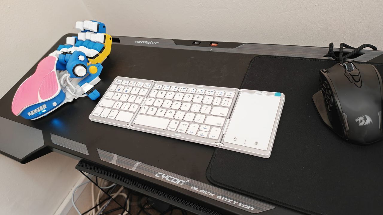 The SEENDA Foldable Bluetooth Keyboard unfolded next to an Azeron Keyzen