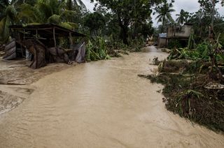 Overflowing water from a nearby river floods homes near the western town of Leoganne in Haiti on Oct. 5, 2016.