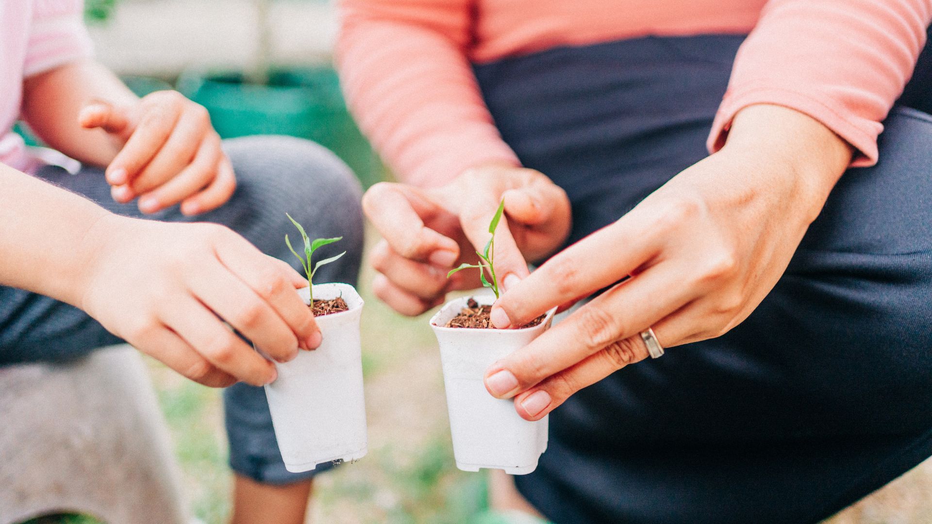 A woman planting seeds and plant pots with a child