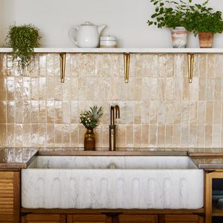 kitchen with a classic fluted reclaimed marble kitchen sink with a tall splashback of neutral terracotta tiles and opening shelving