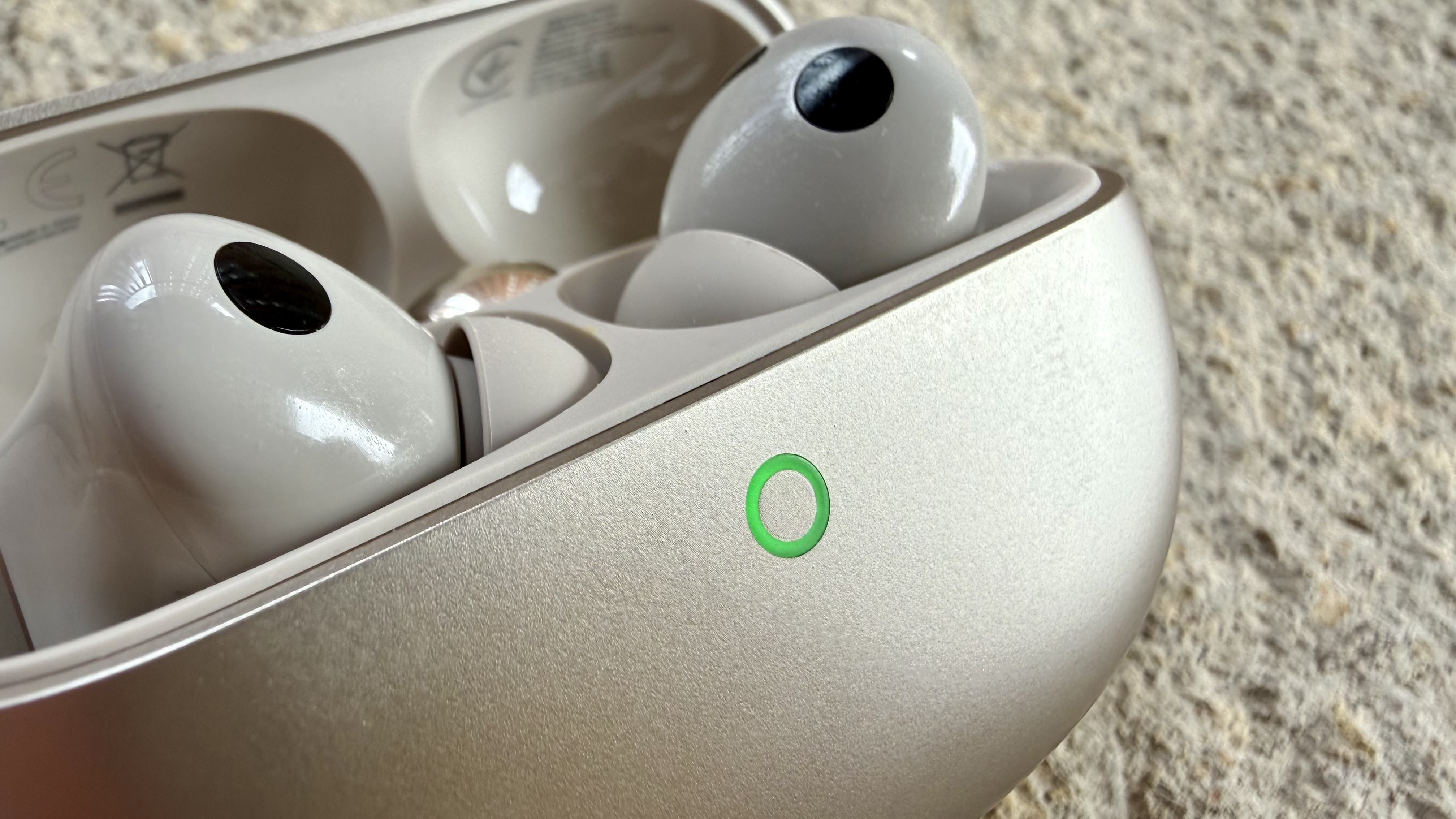 A close up of the Huawei FreeBuds Pro 5 in their charging case with the green light on