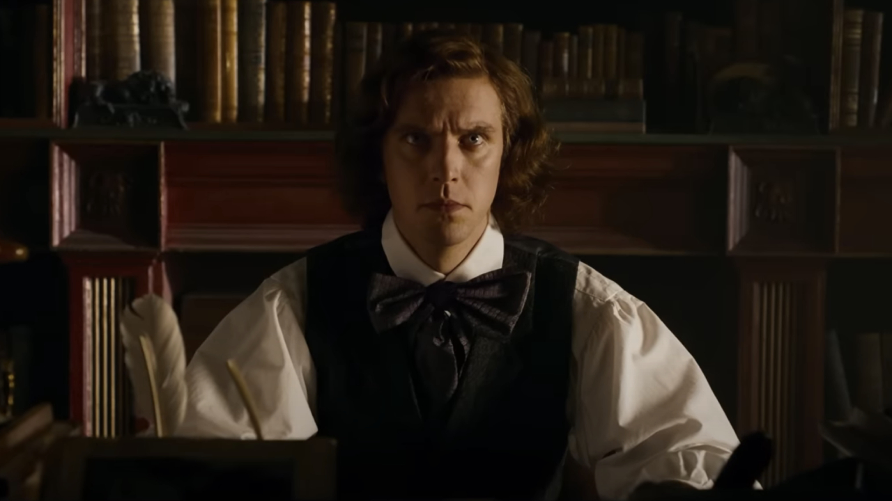 Dan Stevens as Charles Dickens writing with a quill in The Man Who Invented Christmas