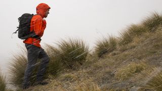 A hiker battles the storm heading uphill