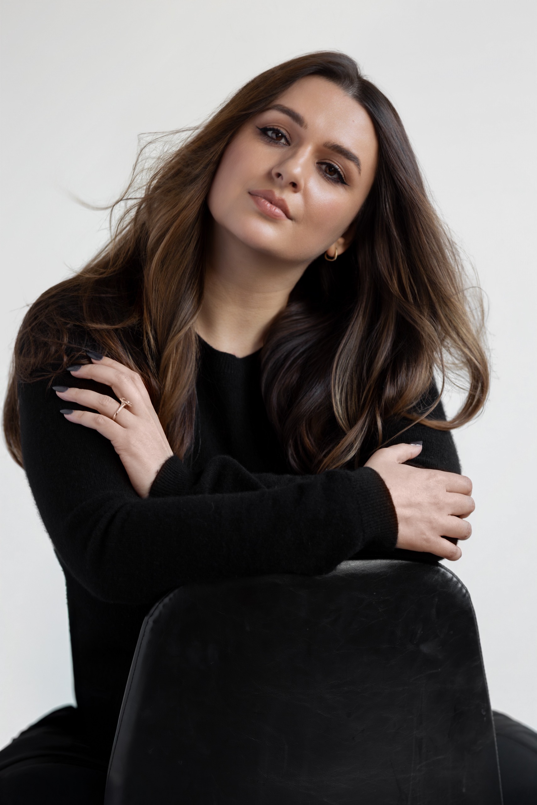 a white woman with brown hair in a black sweater and blue jeans
