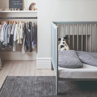 A children's bedroom painted in a dove grey with a matching floor and a grey kids bed which used to be a cot