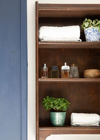 wooden shelf storage in a blue and white bathroom. Peter Grech transformed his bathroom into a stylish sanctuary, and won our 2018 Real Homes award for best bathroom