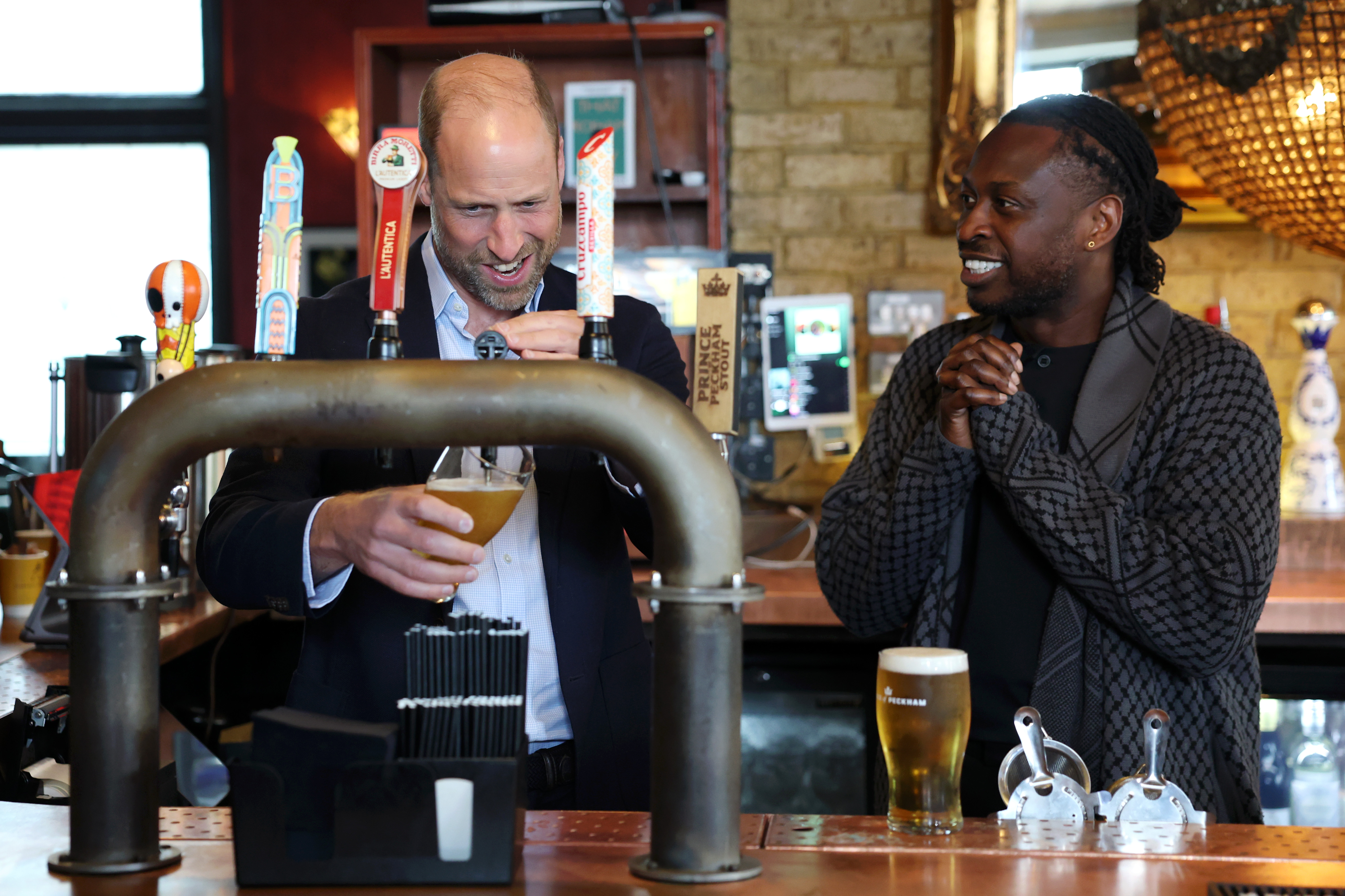LONDON, ENGLAND - JUNE 03: Prince William, Prince of Wales pours a pint alongside Clement Ogbonnaya during his visit to The Prince of Peckham pub in Peckham on June 03, 2026 in London, England. The Prince of Wales visited grassroots initiatives encouraging positive social change. (Photo by Chris Jackson/Getty Images)