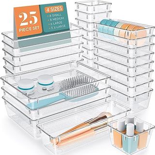 Deep clear plastic drawer organizers with bathroom items inside. Stacked on top of one another