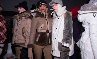 Three models, two in caramel jackets and one in a white jacket with fur sleeves