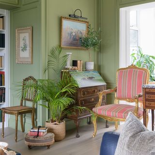 green living room with antique bureau and chair