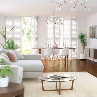living room with white walls and window with privacy shutter and wooden flooring with white sofa