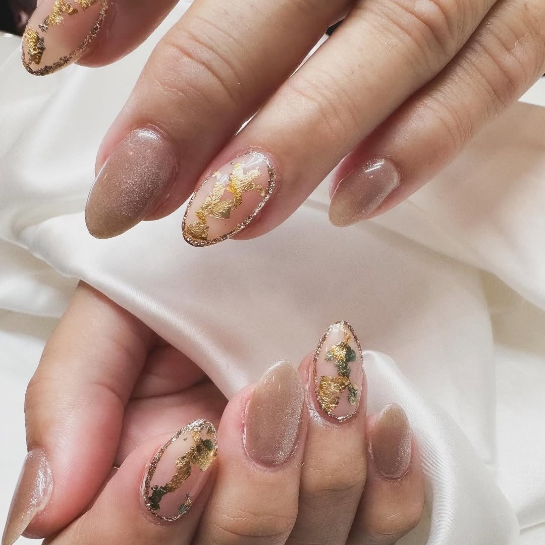 A shimmery nude manicure with gold foil detailing.
