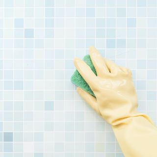 plastic glove scrubbing blue bathroom tile