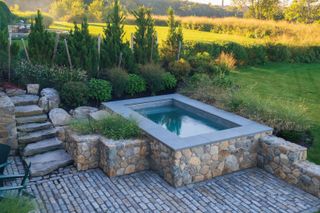 above ground pool with stone walls surrounding it