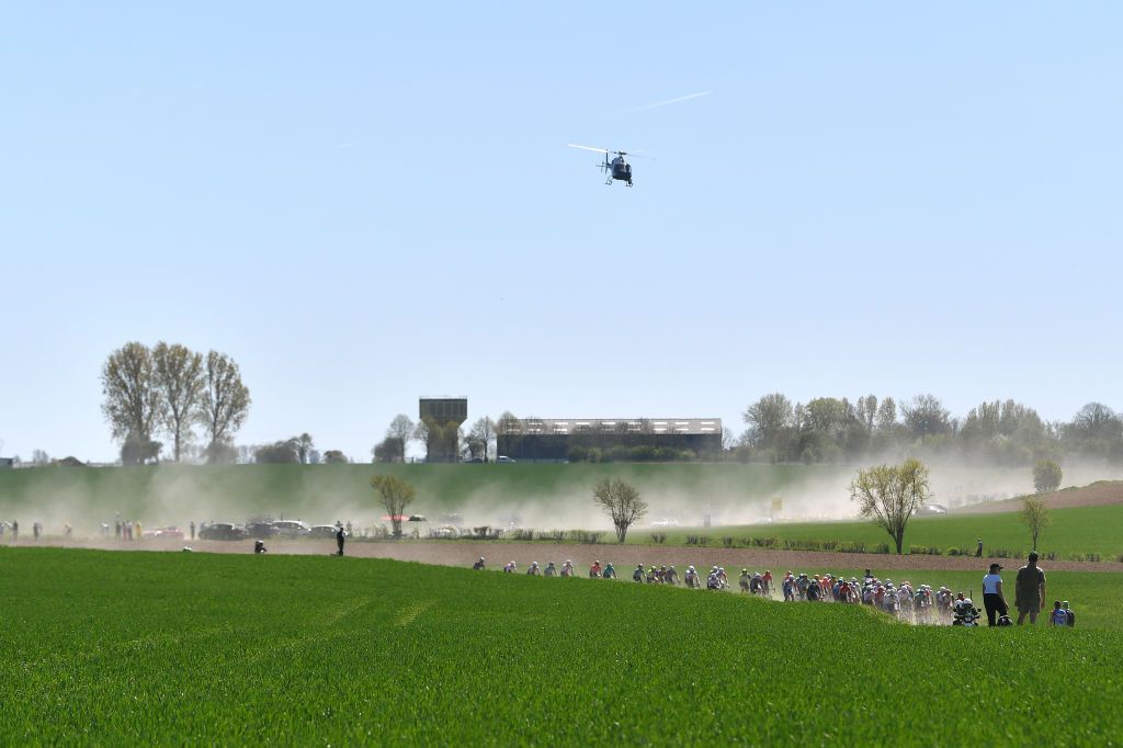 ROUBAIX FRANCE APRIL 17 A general view of the peloton compete passing through a dusty cobblestones sector landscape during the 119th ParisRoubaix 2022 Mens Elite a 2572km one day race from Compigne to Roubaix ParisRoubaix WorldTour on April 17 2022 in Roubaix France Photo by Luc ClaessenGetty Images
