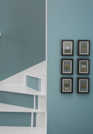 Staircase with risers painted in blue with white and white treads and blue wall