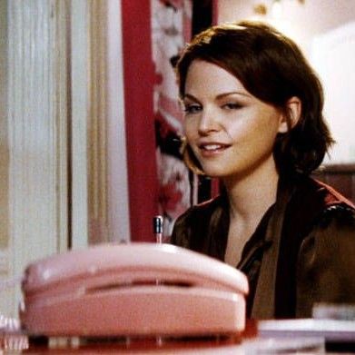 Woman looking at a phone waiting for it to ring.