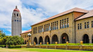 Stanford University's front lawn and main building on a sunny day, with the bell tower in the background