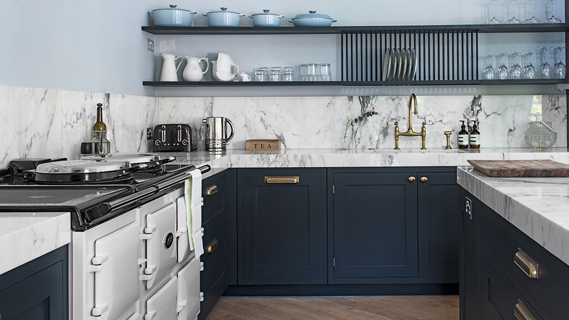 Blue kitchen with marble countertops and splashback