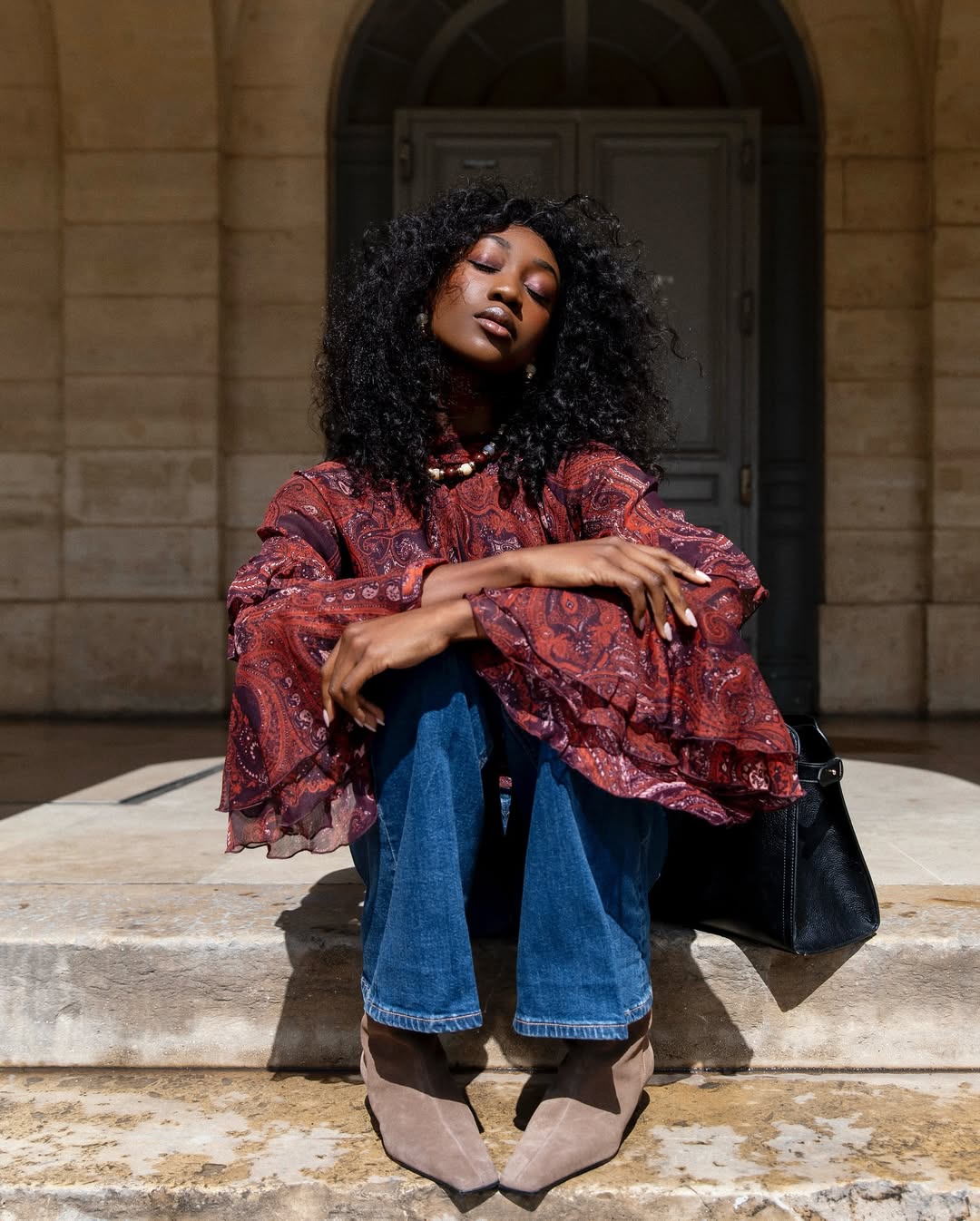 Emmanuelle Koffi wears a burgundy Mango blouse