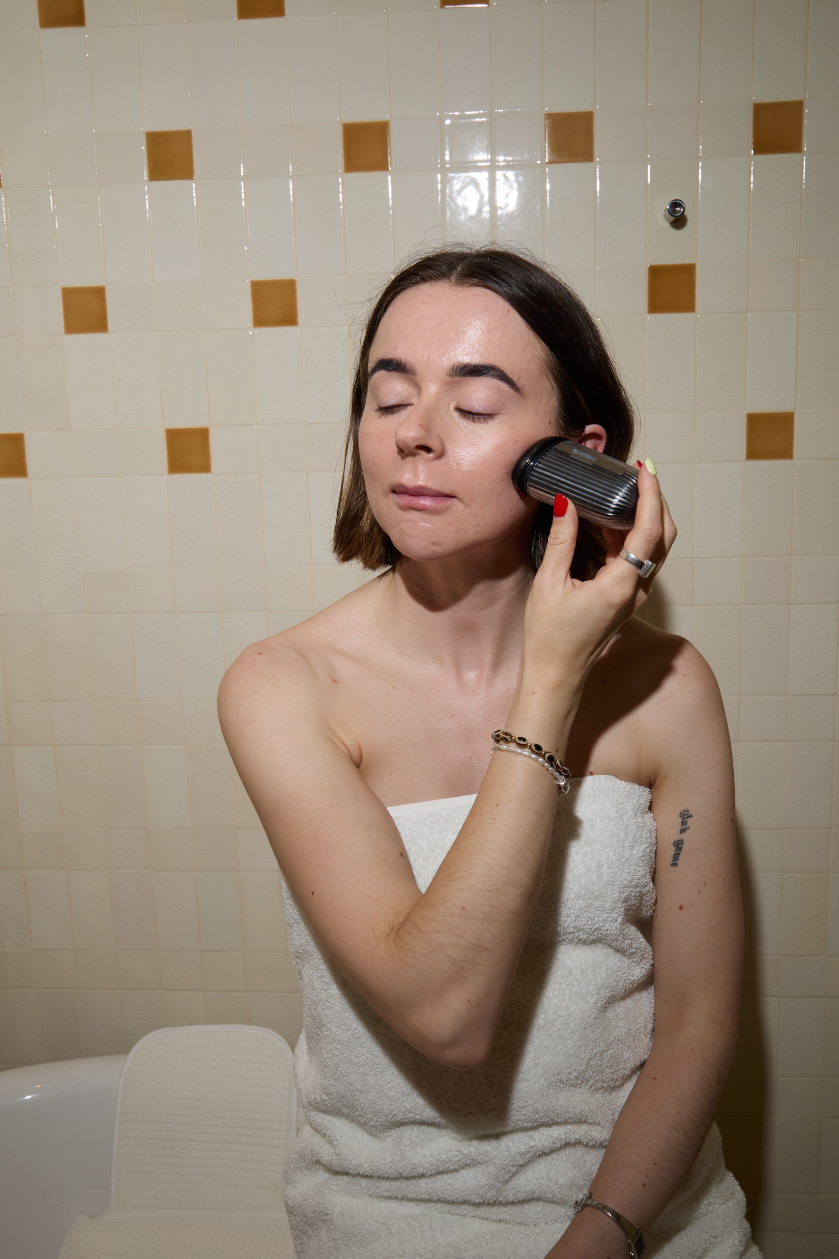 Grace Day using the Dr Levy skincare tool in a bathroom