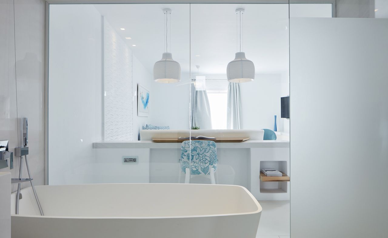 A bathroom suite showing a large bath and mirrored unit