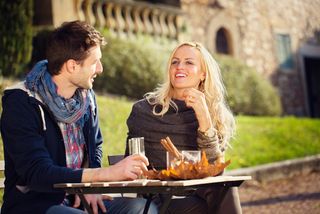 A couple sits at an outdoor cafe table