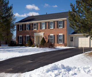 Colonial home in winter with a clear driveway