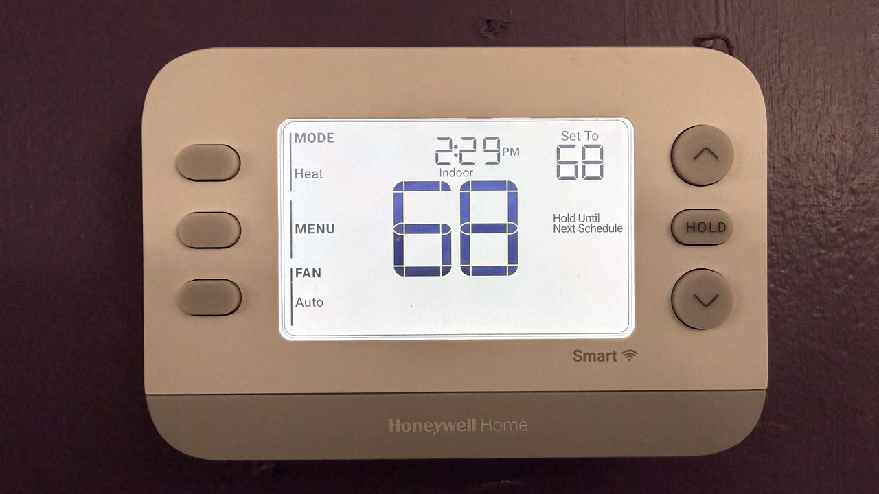 Honeywell Home X2S Smart Thermostat with backlight illuminated, showing current and target temperatures