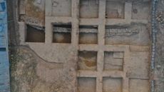 An aerial view of an ancient temple with square rooms and stone walls.