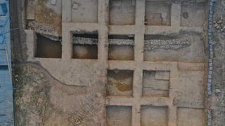 An aerial view of an ancient temple with square rooms and stone walls.