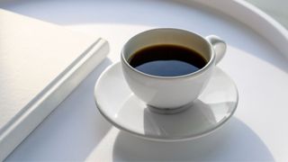 Ceramic mug and saucer with black coffee