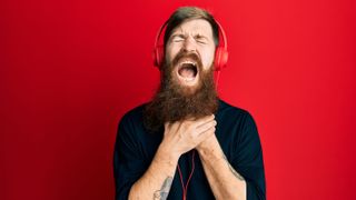 Man using headphones in pain.
