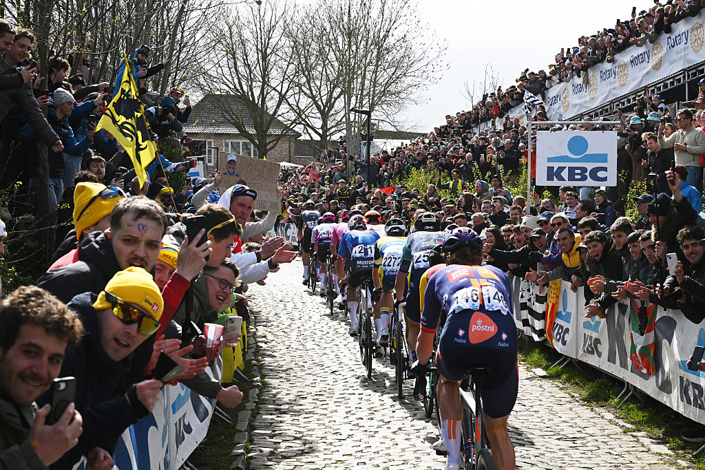 Group of riders climb up a cobbled path
