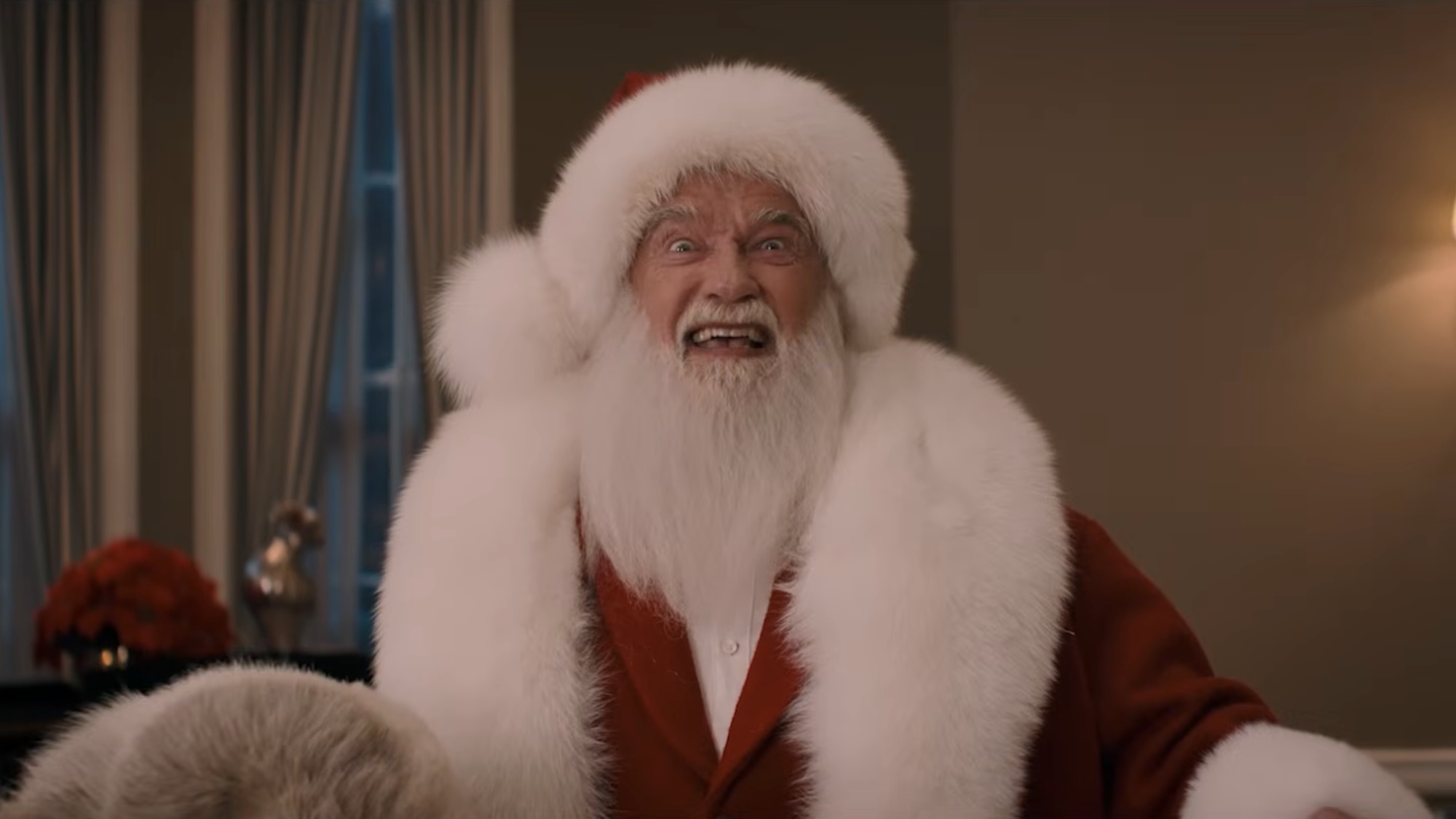 Arnold Schwarzenegger in Santa's suit saying "I'm Back" in the teaser for The Man with the Bag. 