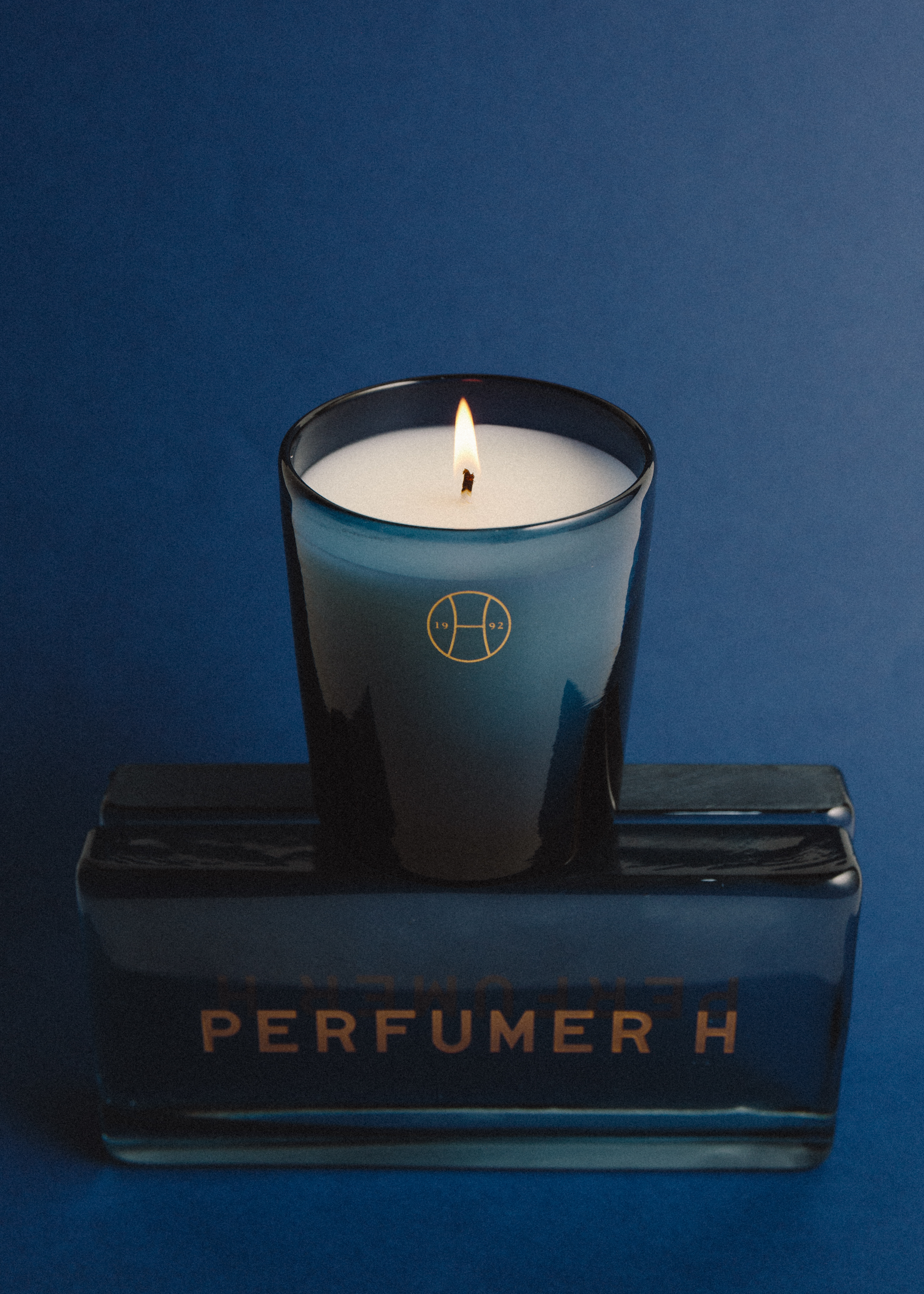 burning candle in blue glass holder