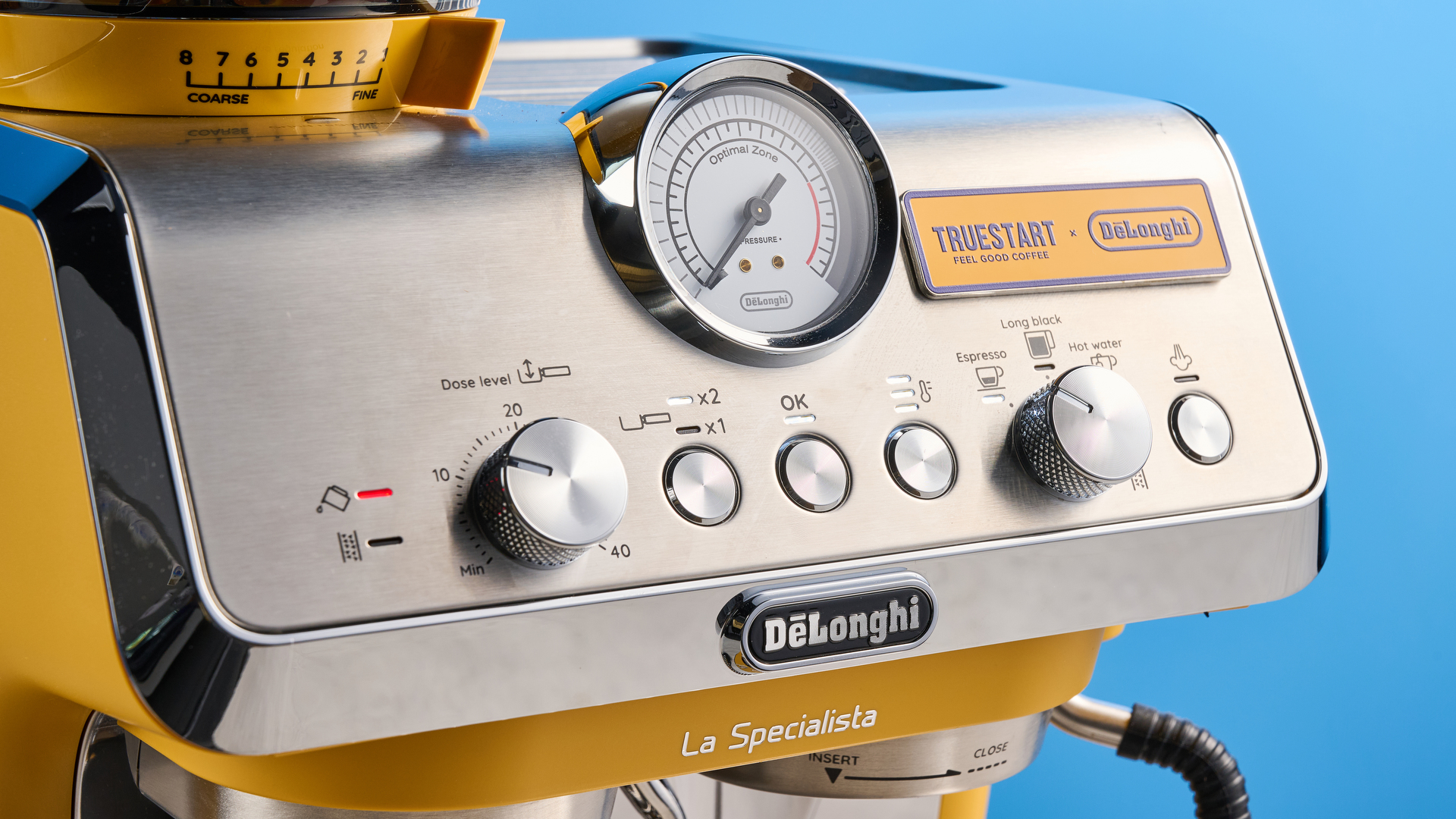 the de&#039;longhi la specialista arte evo special edition truestart edition, with yellow body, showing the espresso machine attachments like tamper, tamping collar, grinder, and control buttons