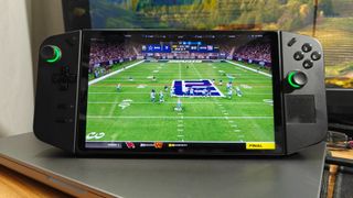 Best Handheld Gaming Devices 2024 - Lenovo Legion Go on top of a laptop while watching a football game.